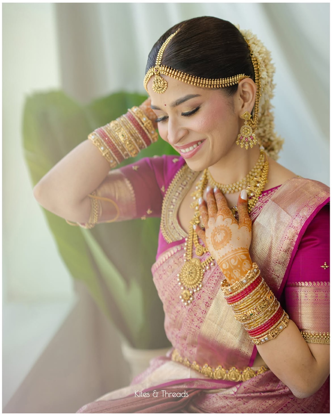 Tanisha adjusting her jewellery, close-up in pink and gold