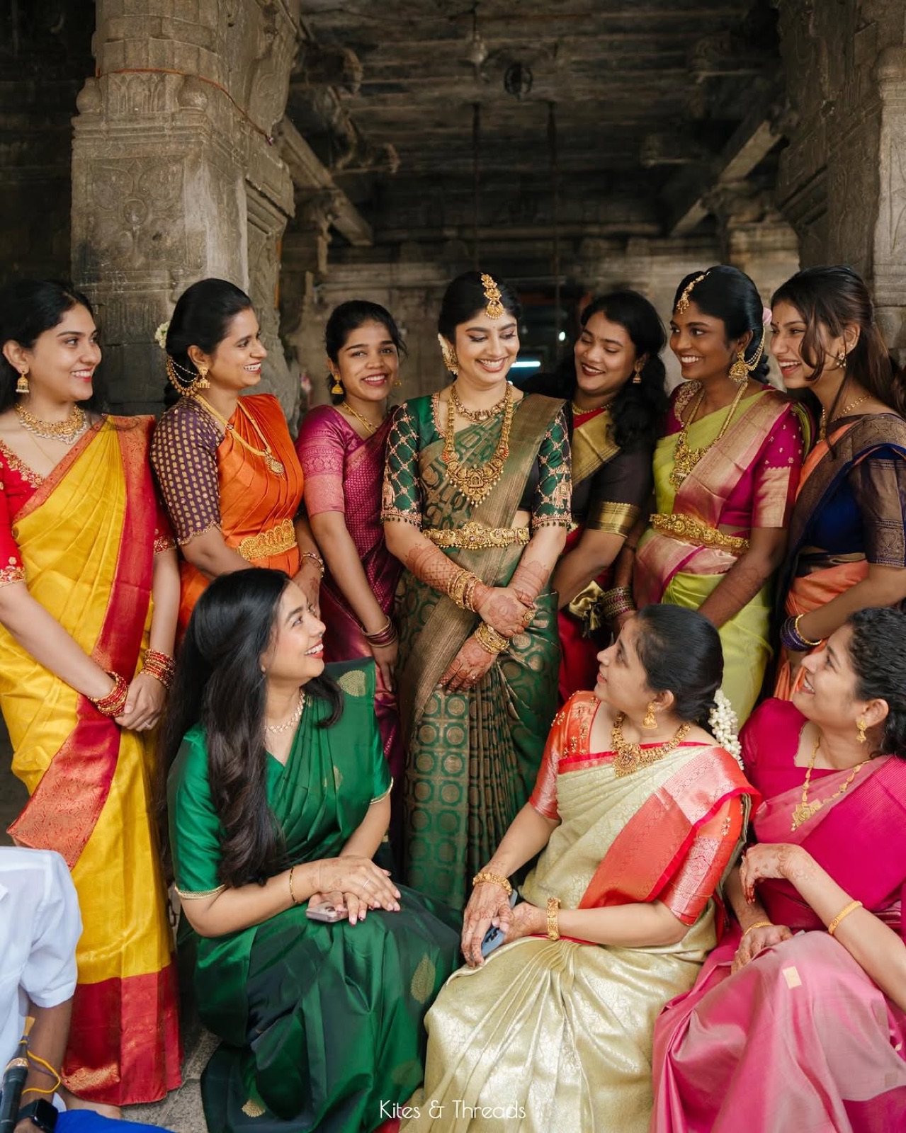 Family and friends gathered around the bride in green and gold