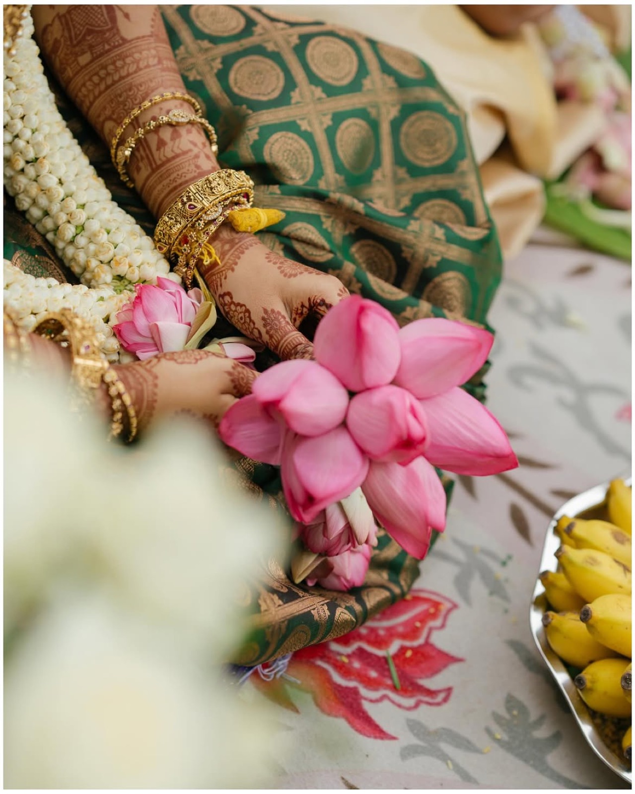 A bride holding a jasmine flower, detail of her wedding jewellery