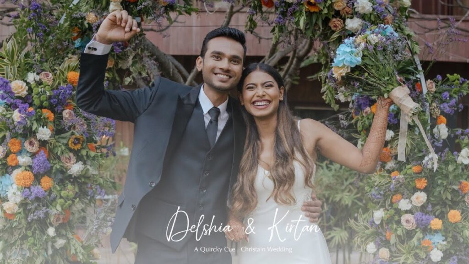 Delshia and Kirtan laughing together under a floral arch